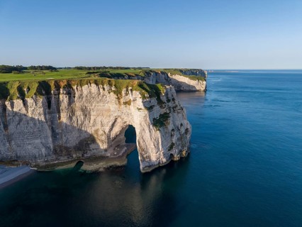 Aerial view of La Manneporte rock gate, behind it the distinctive Pointe de la Courtine promontory,