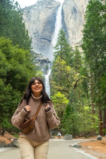 Young woman smiling while walking on a path, exploring the beautiful nature of yosemite national