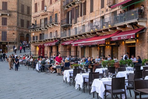 Tourists, sights and restaurants on the famous Piazza del Campo, Siena, Tuscany, Italy