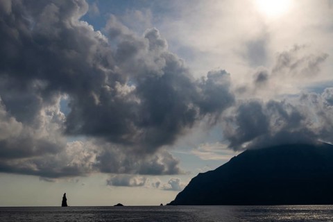 Silhouette of a towering monumental rock pin off the island of Filicudi, Aeolian or Lipari Islands,