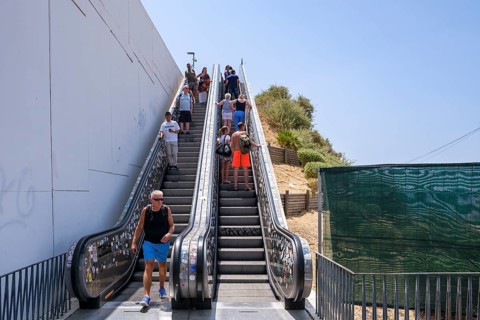 People on an outdoor escalator in sunny weather, Albufeira, Faro, Portugal