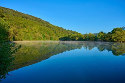 Clear river flanked by wooded mountains, captured in morning haze, Boxtal, Main-Boxtal, Tauber
