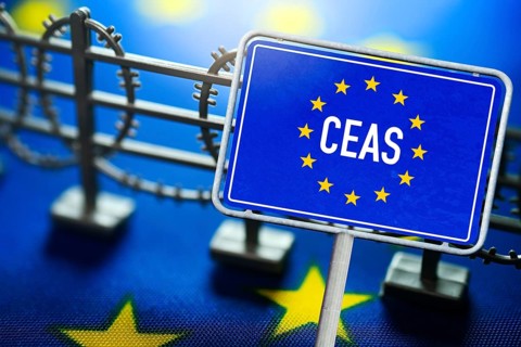 EU sign with CEAS inscription in front of miniature fence and EU flag, symbolic photo of European