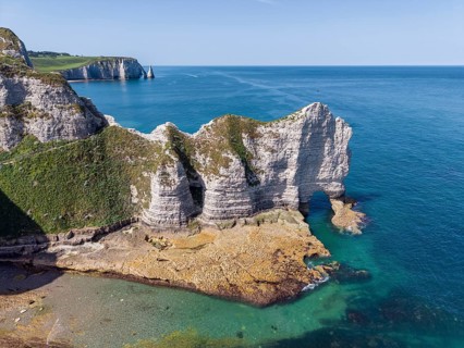 Aerial view of the Falaise d'Amont rock formation with the Porte d'Amont rock gate at low tide,