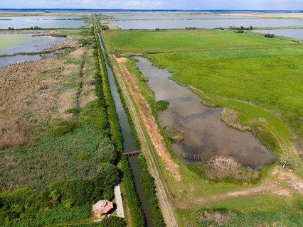 Aerial view of a canal stretching through vast fields and nature, aerial view, Hortobagyer fish