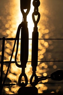 Part of the rigging of a sailing ship, anchoring, steel cables, back light, sunset, silhouette,