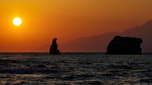 Peaceful sunset over the sea with a rock and distant mountains, sunset, South of the Amari Basin,