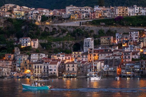 Motorboat against the backdrop of Scilla in the evening, Strait of Messina, Calabria, Italy