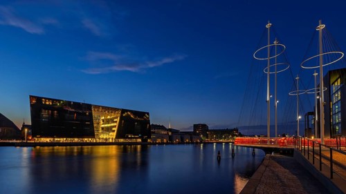 Beleuchtete moderne Gebäude am Wasser bei Nacht, klare Nachtatmosphäre, Kopenhagen, Dänemark,