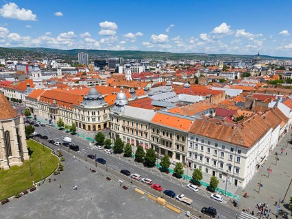 View of an urban landscape with historic buildings and red roofs under blue sky, aerial view,