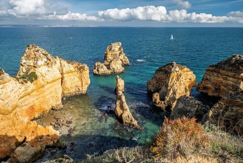 Ponte da Piedade in the Algarve region features stunning Atlantic cliffs. A small boat explores the