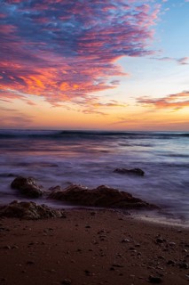 Dramatic sunset on the ocean with rocks and intense colors in the sky, sunset, Praia do Amado,