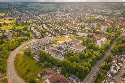 Aerial view of a city with green fields, roads and a view of a large building, new IGZ, Herrenberg