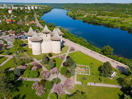 Castle complex in parkland with river and neighboring settlement, aerial view, Soroca fortress,