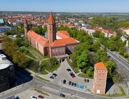 Castle in urban surroundings, with distinctive orange roofs and surrounding roads, aerial view,