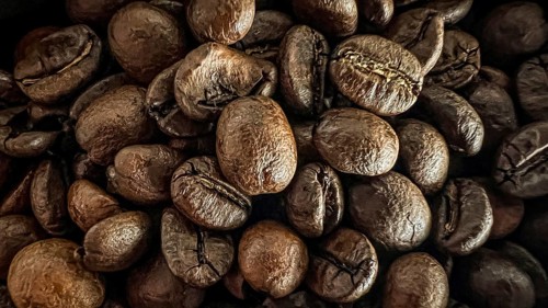 Close to dark coffee beans, the texture is detailed and intense, coffee beans