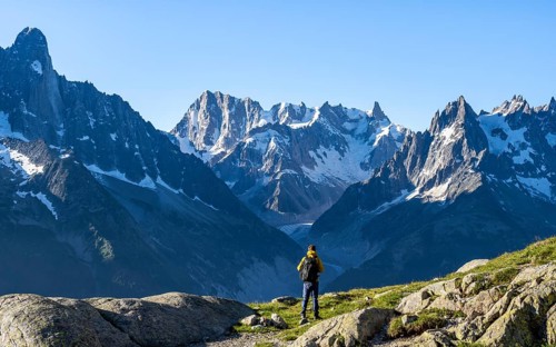 Young man in front of impressive mountain landscape in morning light, picturesque mountain