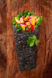 Shawarma in black lavash, on a wooden background, chicken shawarma, no people