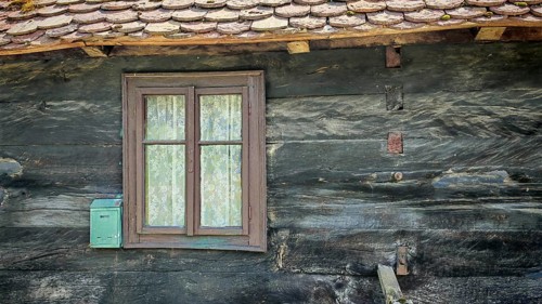 Old traditional wooden house with simple windows, wooden shingles and rustic appearance, classic