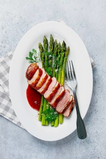 Roast duck breast, with asparagus, with red sauce, on a white plate, homemade, no people