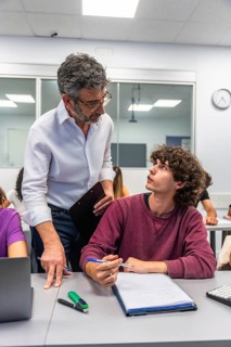 Teacher and student collaborating in a brightly lit educational setting, with the teacher providing