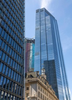 Glass facade of 22 Bishopsgate skyscraper rising above historic building stone architecture, City