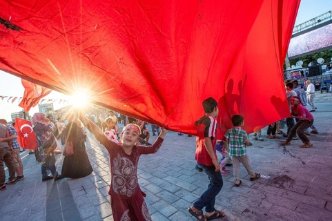 Istanbul, Turkey. 19th July 2016. Children play with a giant Turkish flag among the crowds that