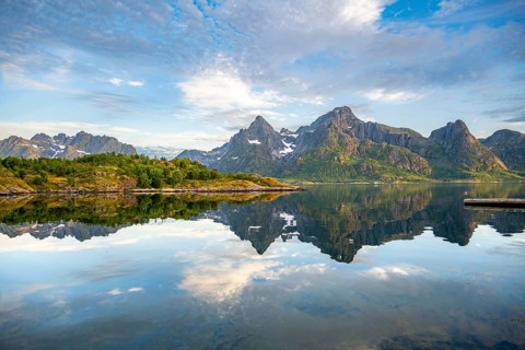 Mountains are reflected in the water in a bay on Raftsund fjord, Vesterålen, Norway