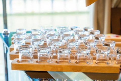 Several small glasses on a wooden tray in an elegant and well-lit room, Schifffahrt, Neckar,