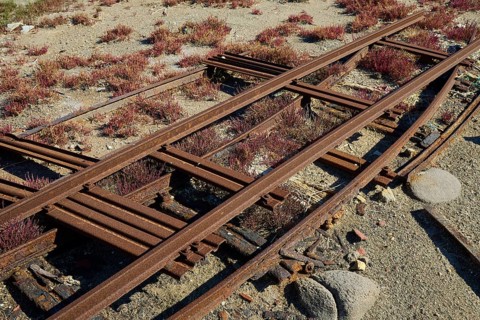Rusted tracks run through a dry landscape covered with vegetation, saltworks, Lost Place, near