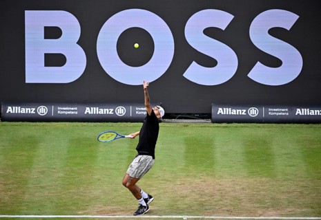Nick Kyrgios (AUS) serving, with a Boss logo on the backboard in the background, BOSS Open 2026,