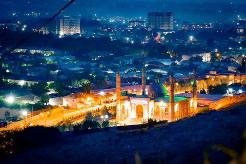 Osh central mosque kyrgyzstan timelapse day to night cityscape glowing green dome minarets urban