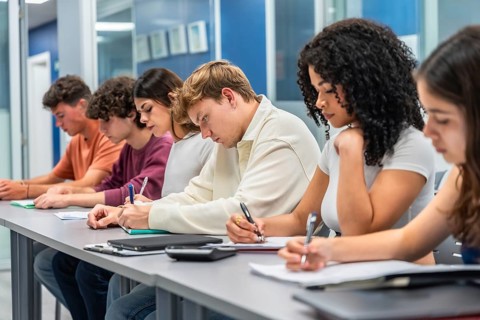 Group of focused students demonstrating concentration and academic effort while taking an exam or