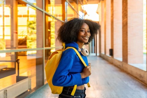 Young african woman, a university student, confidently looking at the camera and smiling while