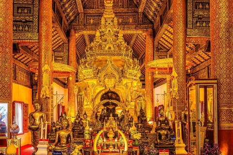 Sumptuous interior with richly decorated wooden ornaments, gilded Buddha statues, Buddhist temple