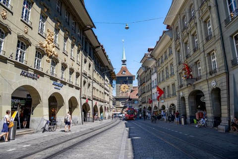 Market alleyway with historic houses, clock tower Zytglogge behind, old town, Bern, Canton of Bern,