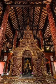 Bronze Buddha statue in a public prayer hall in the Wat Phra Singh Buddhist temple complex, Chiang