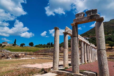Ancient columns in a landscape of ruins under blue sky with clouds, ancient site, archaeological