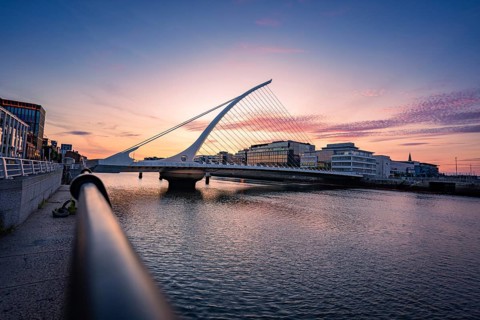Samuel Beckett Brg, bridge over a river at dusk surrounded by urban architecture and colorful