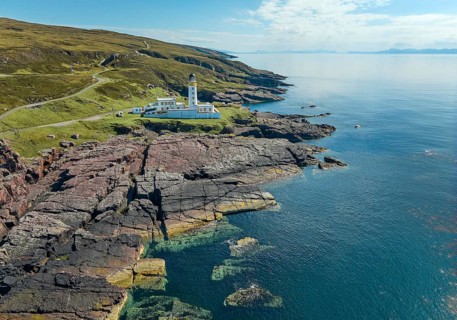Aerial photo of the lighthouse on the rocky red cliffs of Rua Reidh point, Gairloch, Scotland, UK