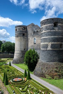 Monumental castle complex from the 13th century with distinctive tower architecture, nestled in a