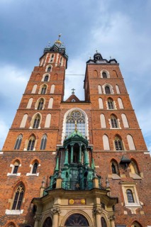 Low angle view of Saint Mary Basilica in Krakow, Poland, with red brick towers, Gothic church