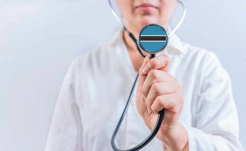 Female doctor holding stethoscope with Botswana flag. National health system of Botswana