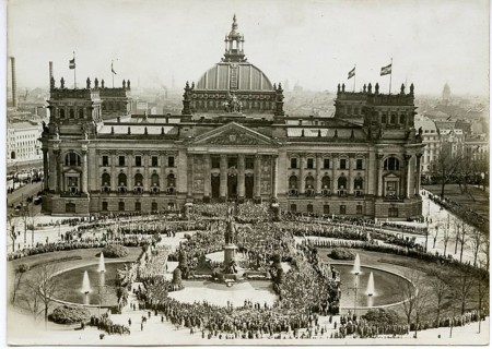 Reichstag, Berlin, public holiday, historic building with dome surrounded by crowds, fountains and