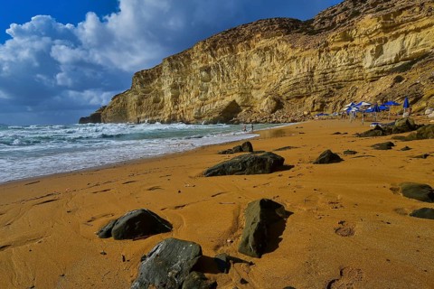 Red Beach, dream beach in the neighboring bay of Matala, large rocks on a quiet beach under a blue