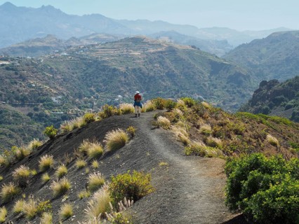 Person on the ridge of a volcanic crater with views of vast valleys and mountains, Caldera de