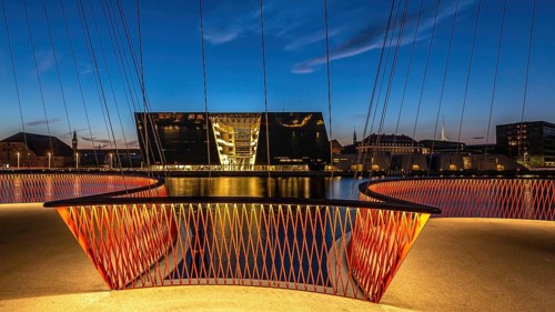 Hintergrund mit moderner Architektur und beleuchteter Brücke bei Nacht, Kopenhagen, Dänemark,