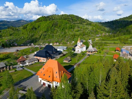Historic buildings and churches in a green hill and forest landscape in sunny weather, aerial view,