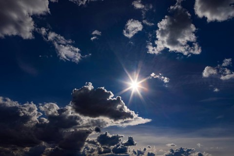Onne glows between cumulus clouds, dramatic cloudy sky, Austria