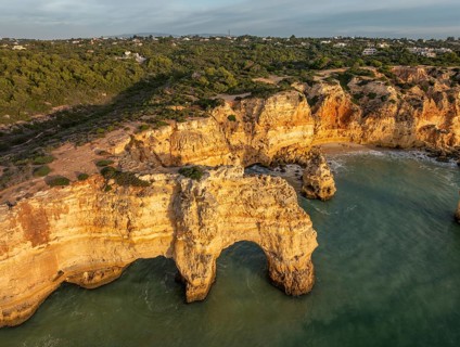 Drone view of Praia da Marinha beach in Algarve, Portugal, with golden cliffs, sea arches,